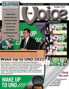 A man in a suit and tie is standing at a podium on the cover of a chamber business update magazine.