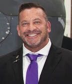 A man in a suit and tie is smiling for the camera.