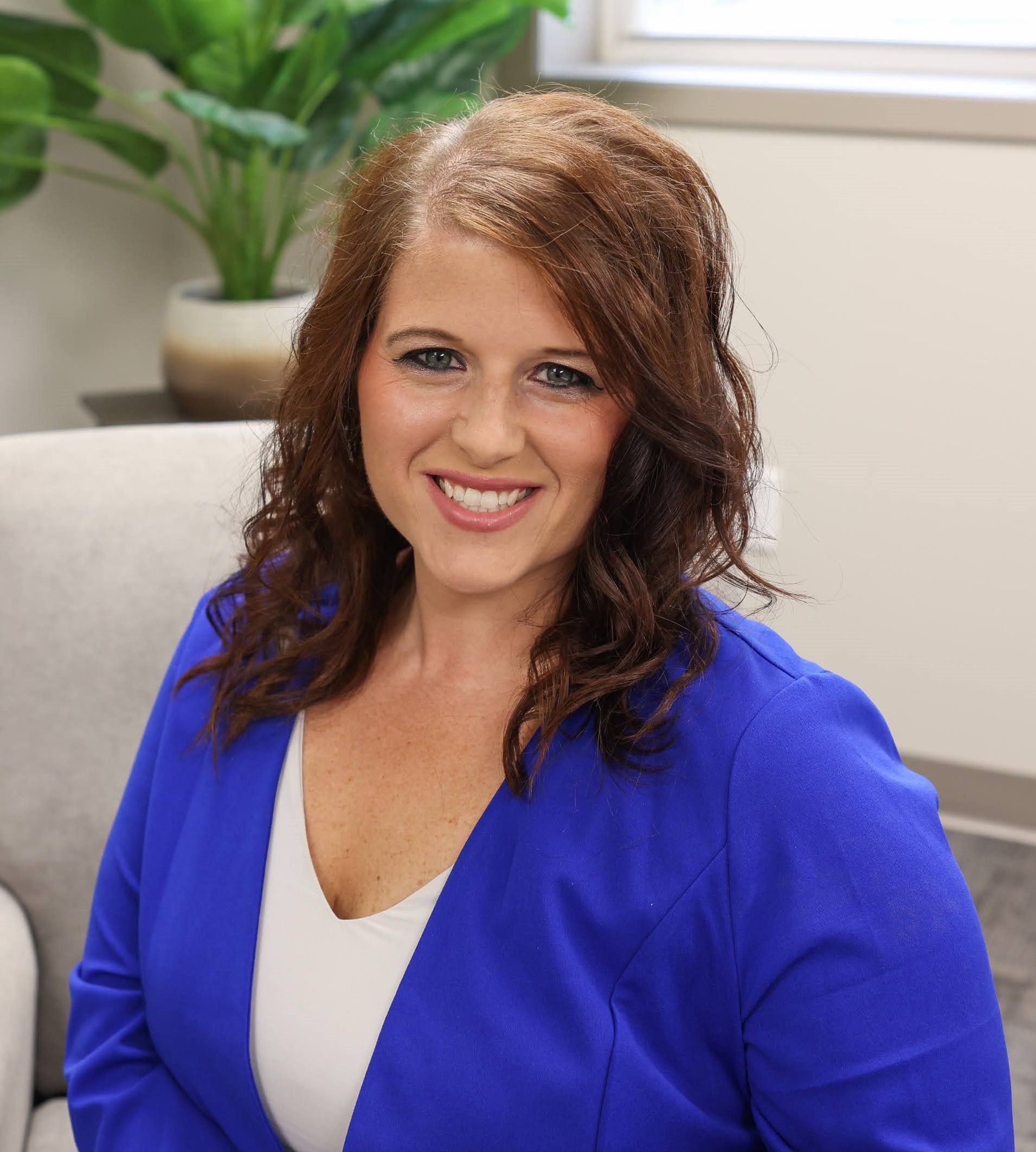 A man in a blue shirt and tie is smiling for the camera.