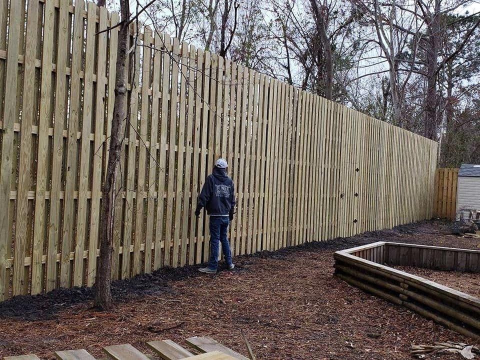 Man Facing Tall Wooden Fence — Wilmington,  NC — J & J Fence