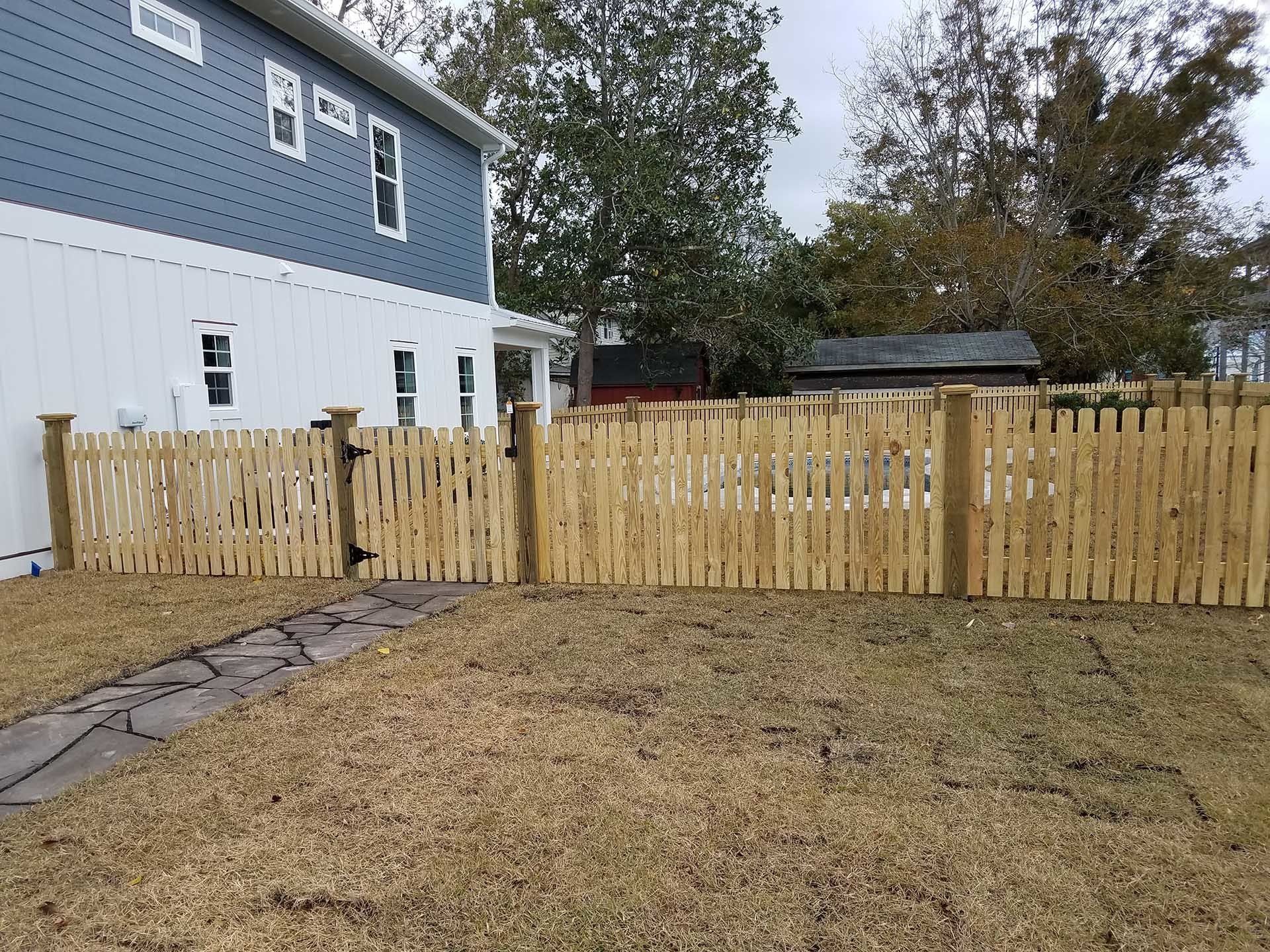 White And Blue House With Wooden Fence — Wilmington,  NC — J & J Fence