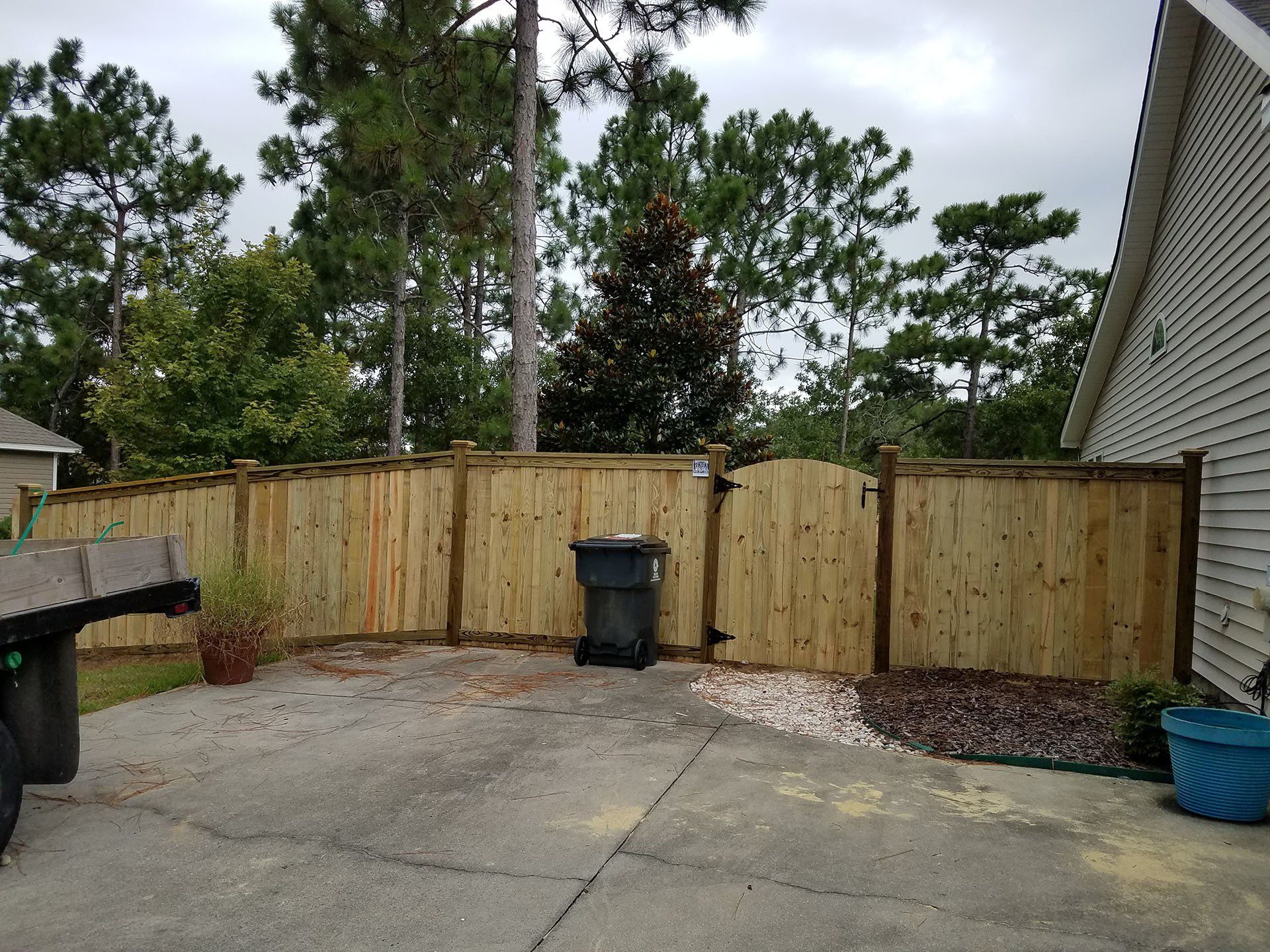 Wooden Fence With Trash Bin Nearby — Wilmington,  NC — J & J Fence