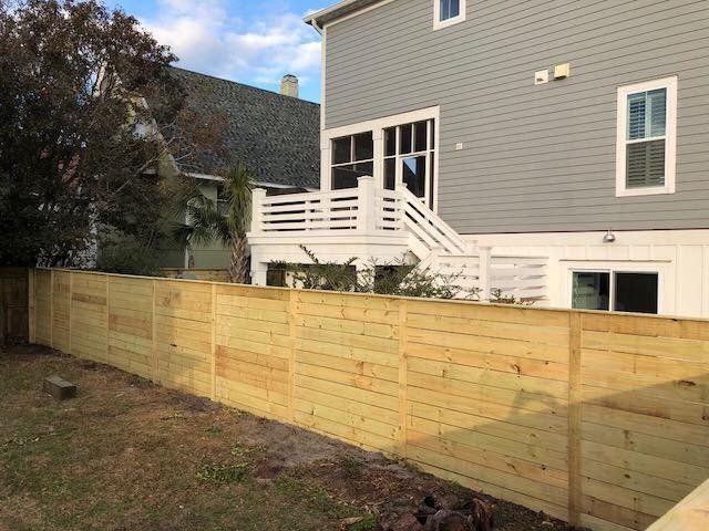 Gray House With Wooden Fence — Wilmington,  NC — J & J Fence