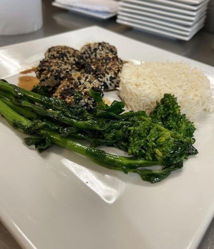 A plate of food with broccoli and rice on a table.