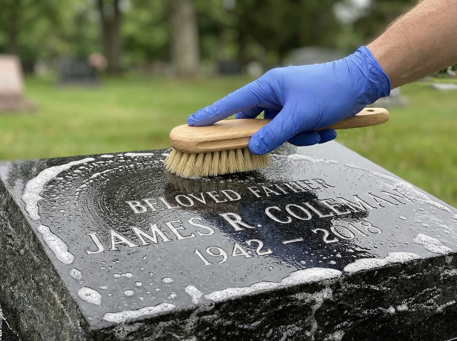 Gently scrubbing granite headstone with soft-bristle brush