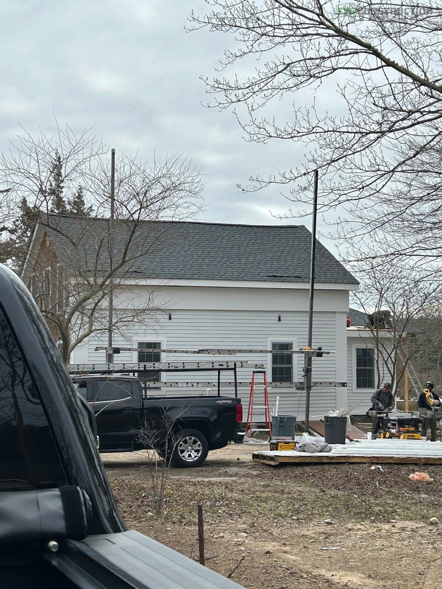 A white house with shingle roofing