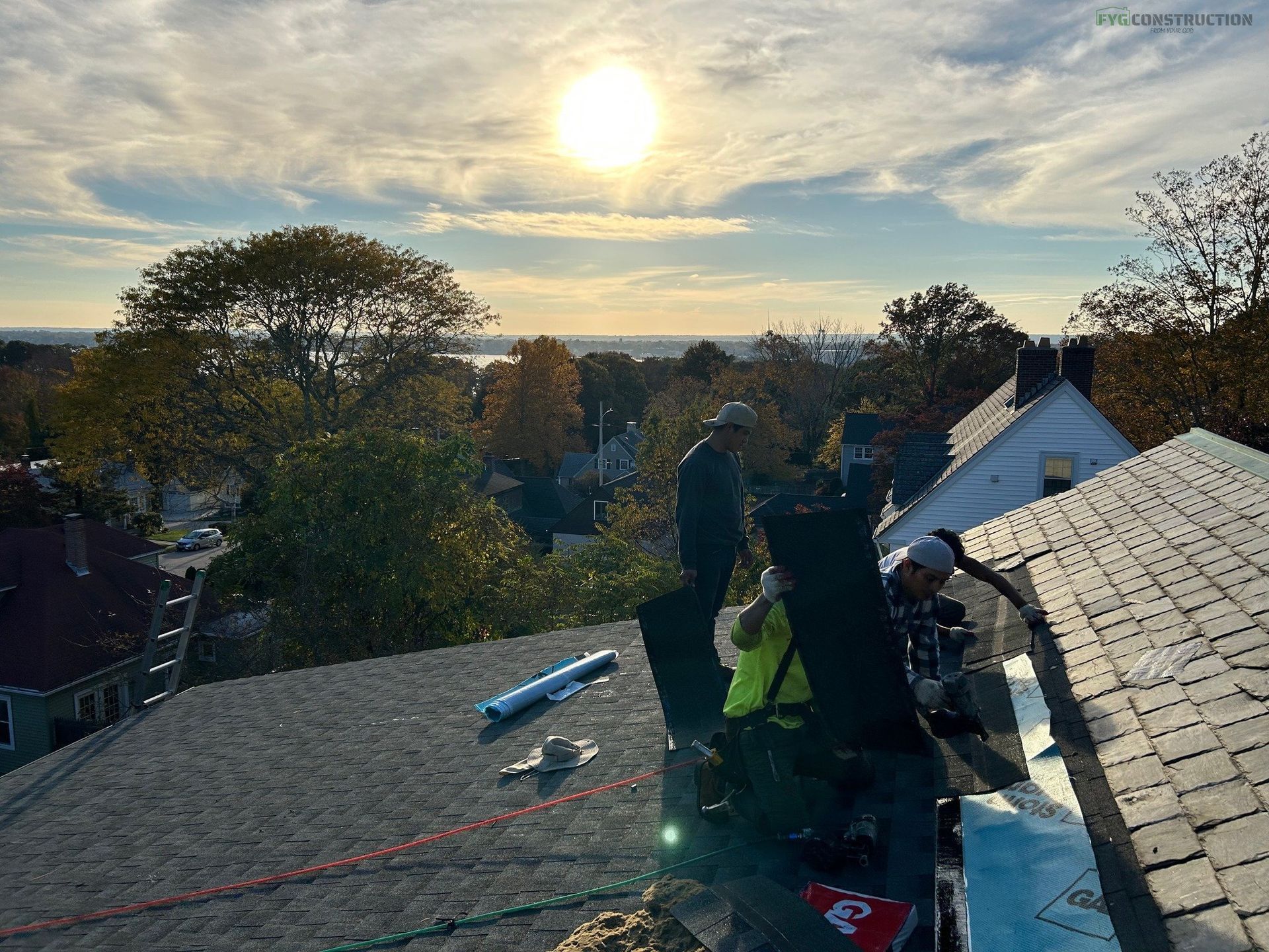 Roofers working on the roof of a house.