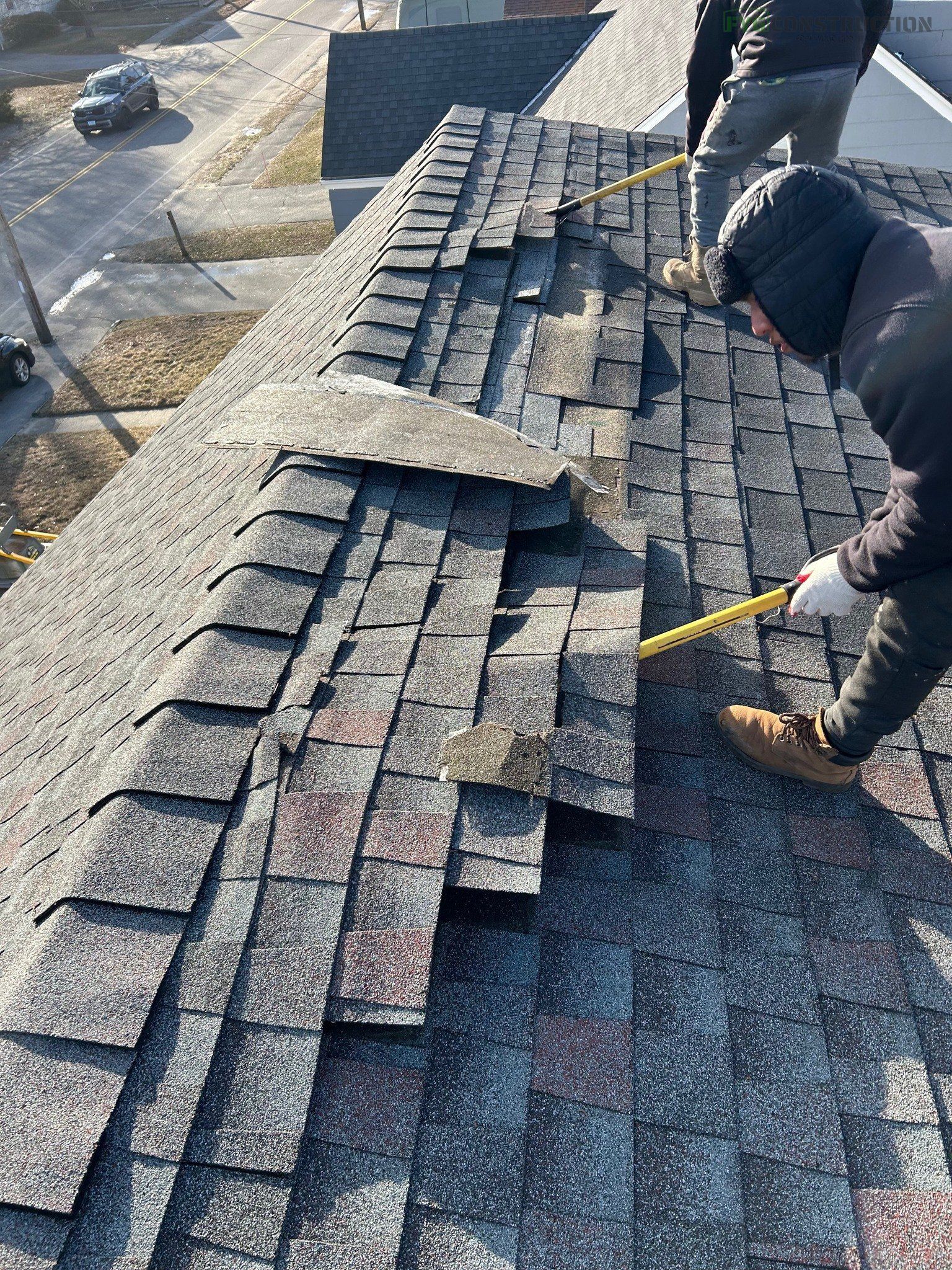 Roofing contractors removing roof shingles