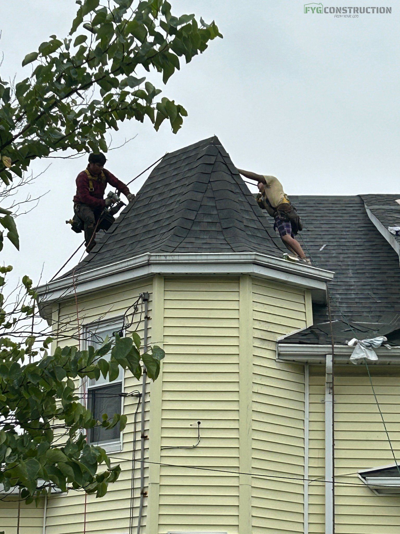 Roofers working on a roof of a house