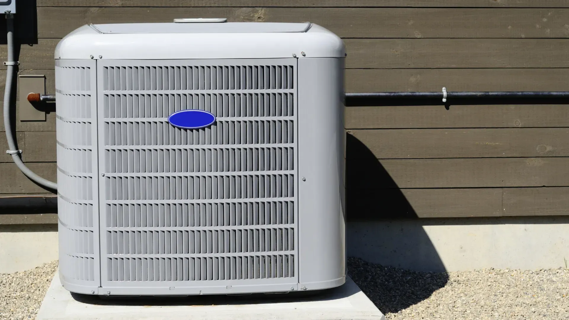 A carrier air conditioner is sitting outside of a building