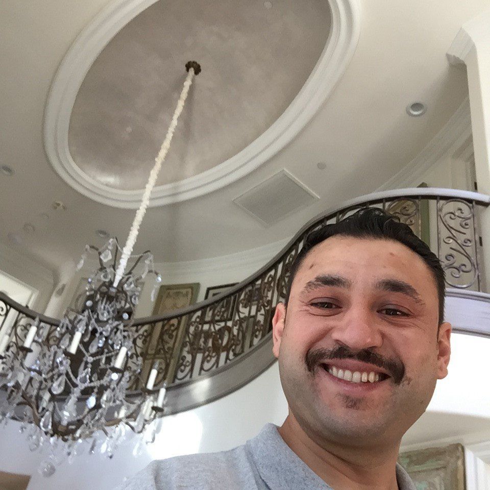 Smiling Electrician After Chandelier Installation — Riverside, CA — Volt Tech Electric