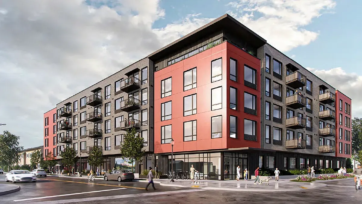 Modern apartment building exterior with red and grey facade, balconies, and street-level storefronts.