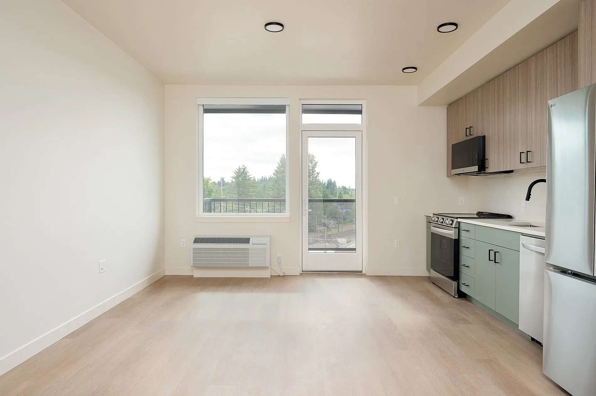 Living room and kitchen area with a balcony view.