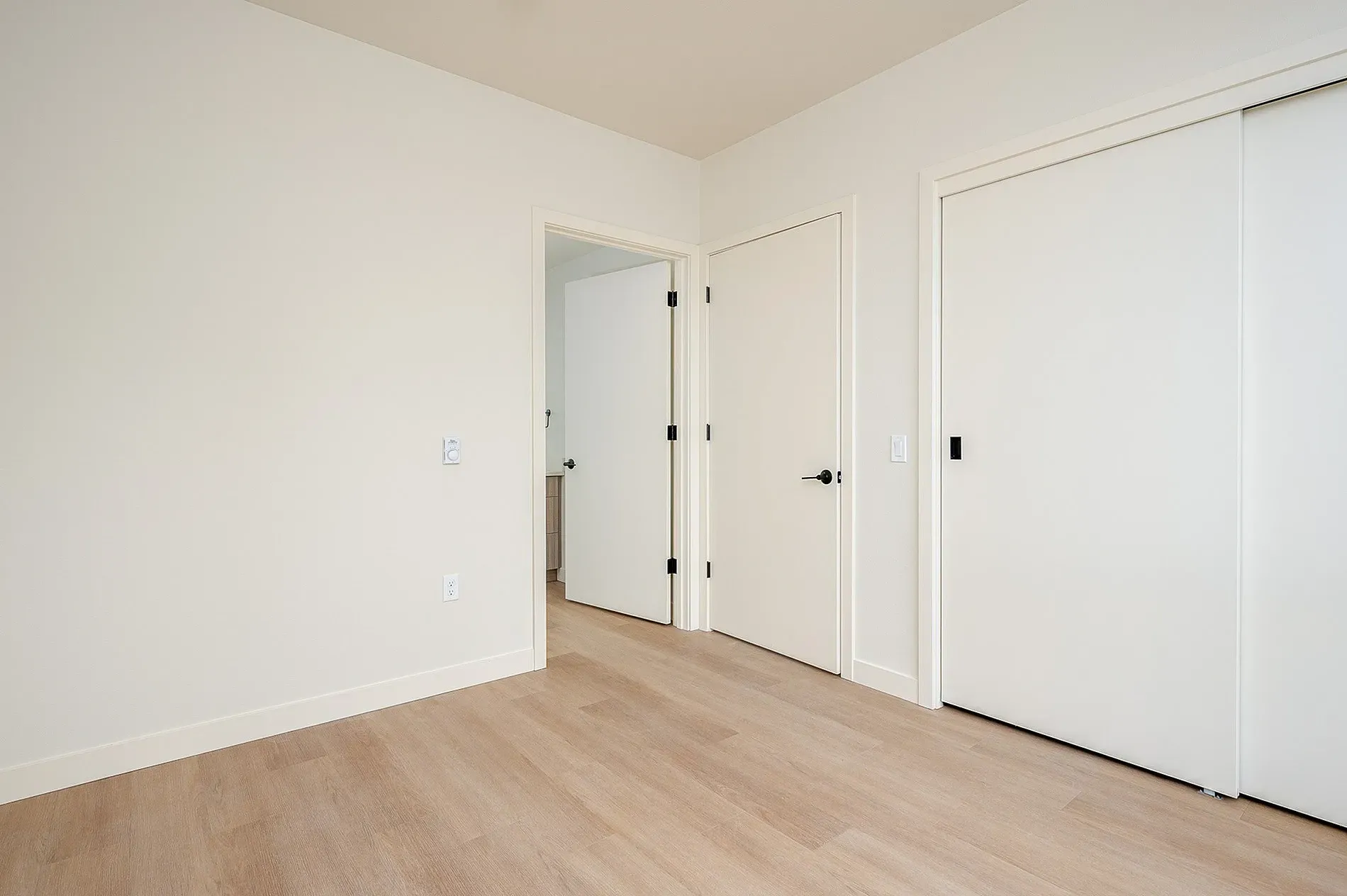 Empty bedroom with light wood floors and large closet