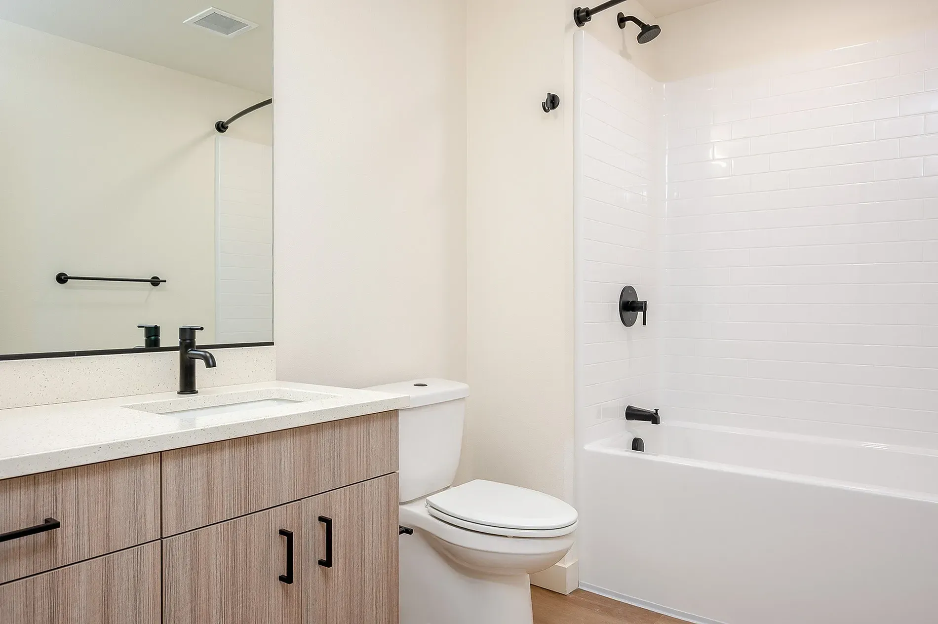 Modern bathroom with vanity, toilet, and shower/tub combo.