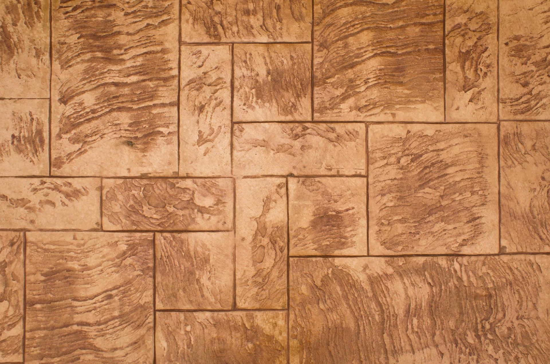 Textured tan stone wall with rectangular masonry blocks