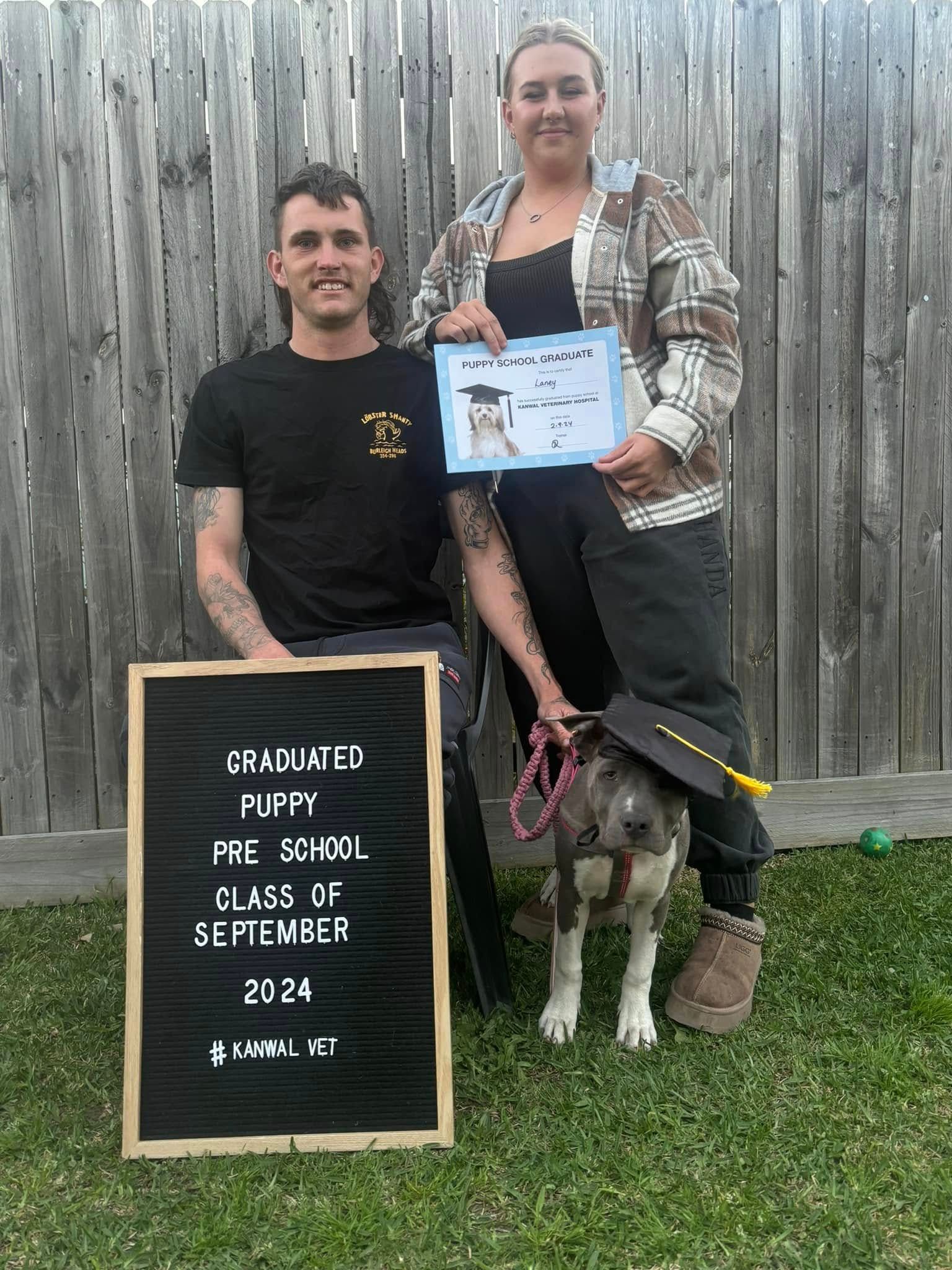 Two People and A Dog Celebrate A Graduation — Kanwal Veterinary Hospital In Kanwal, NSW