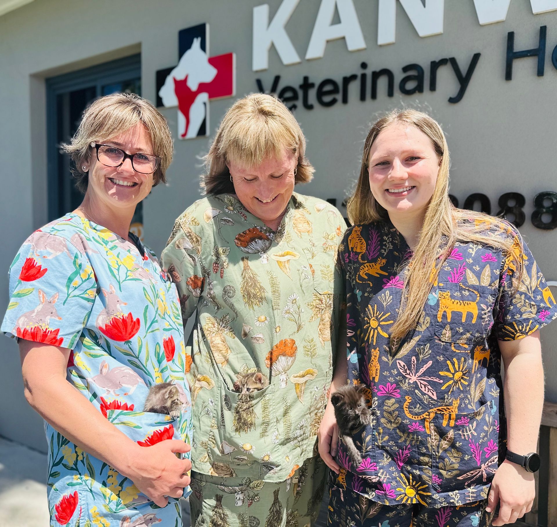 Three women are posing for a picture in front of a veterinary hospital — Kanwal Veterinary Hospital In Kanwal, NSW