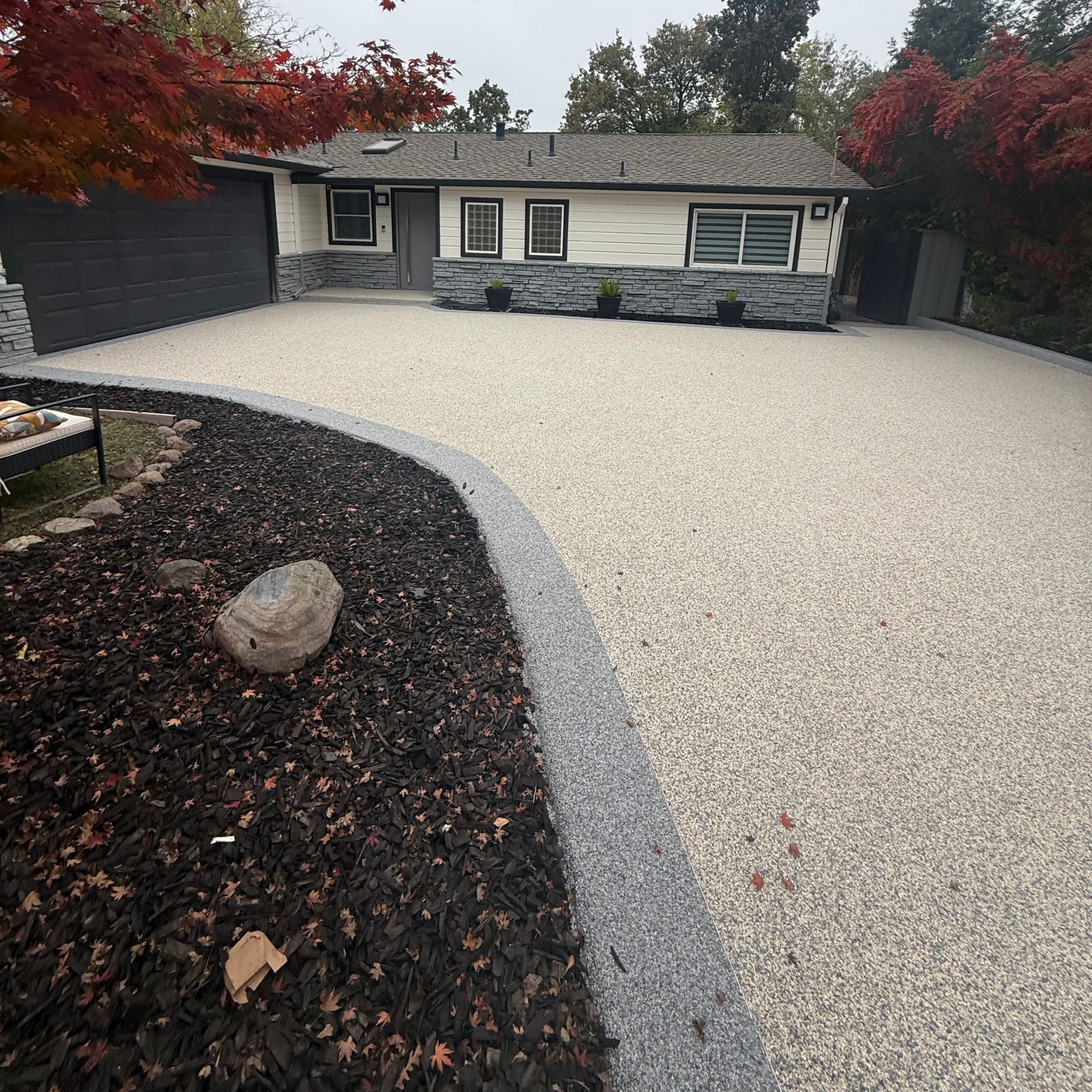 Outdoor dining set on a patio: wooden table with six wicker chairs, dishes set, white floral bowl.