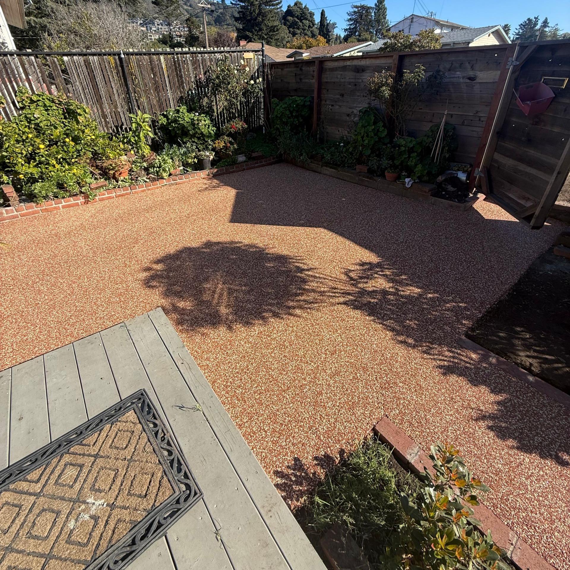 Outdoor dining set on a patio: wooden table with six wicker chairs, dishes set, white floral bowl.