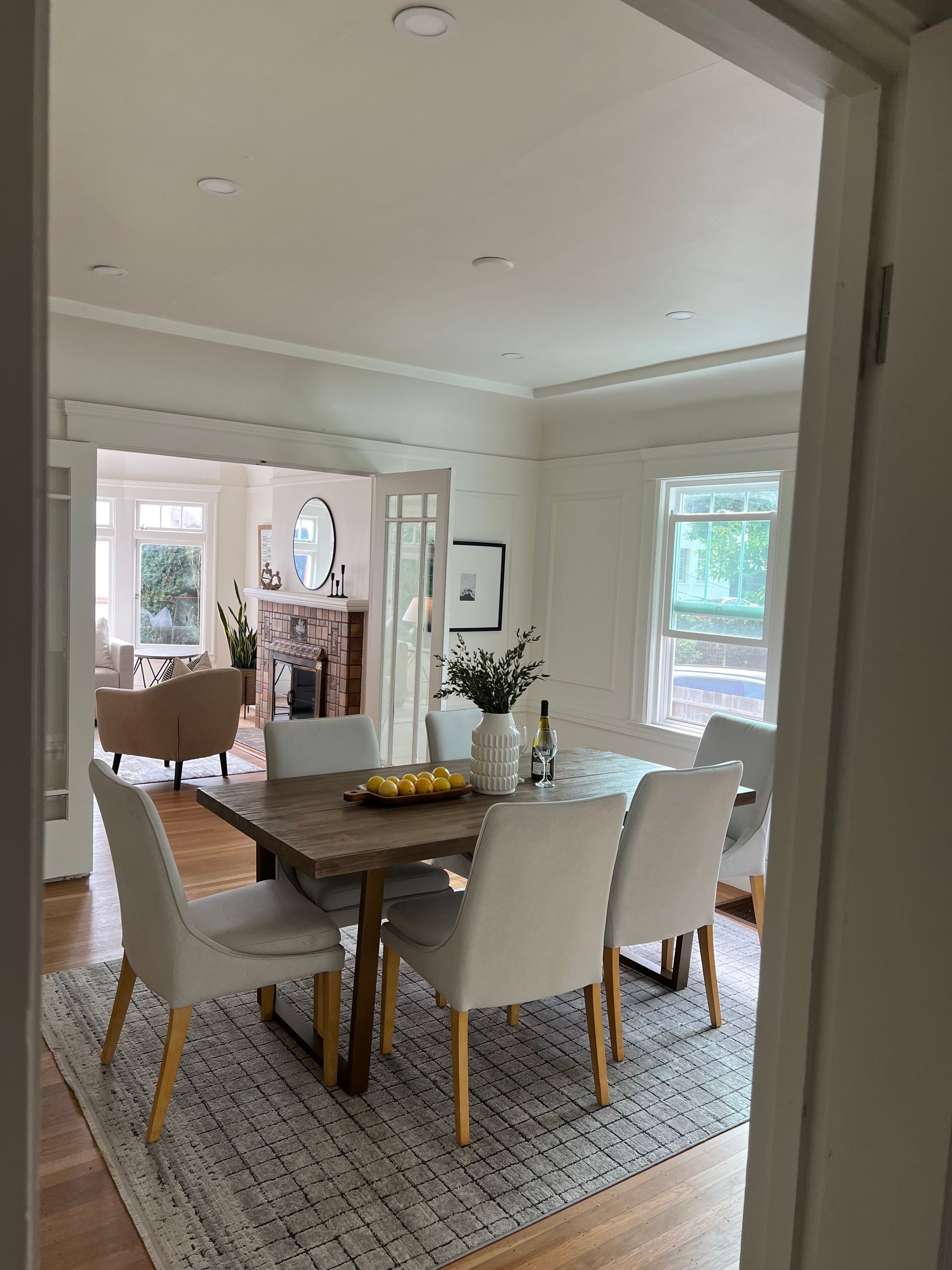 A dining room with a table and chairs and a rug.