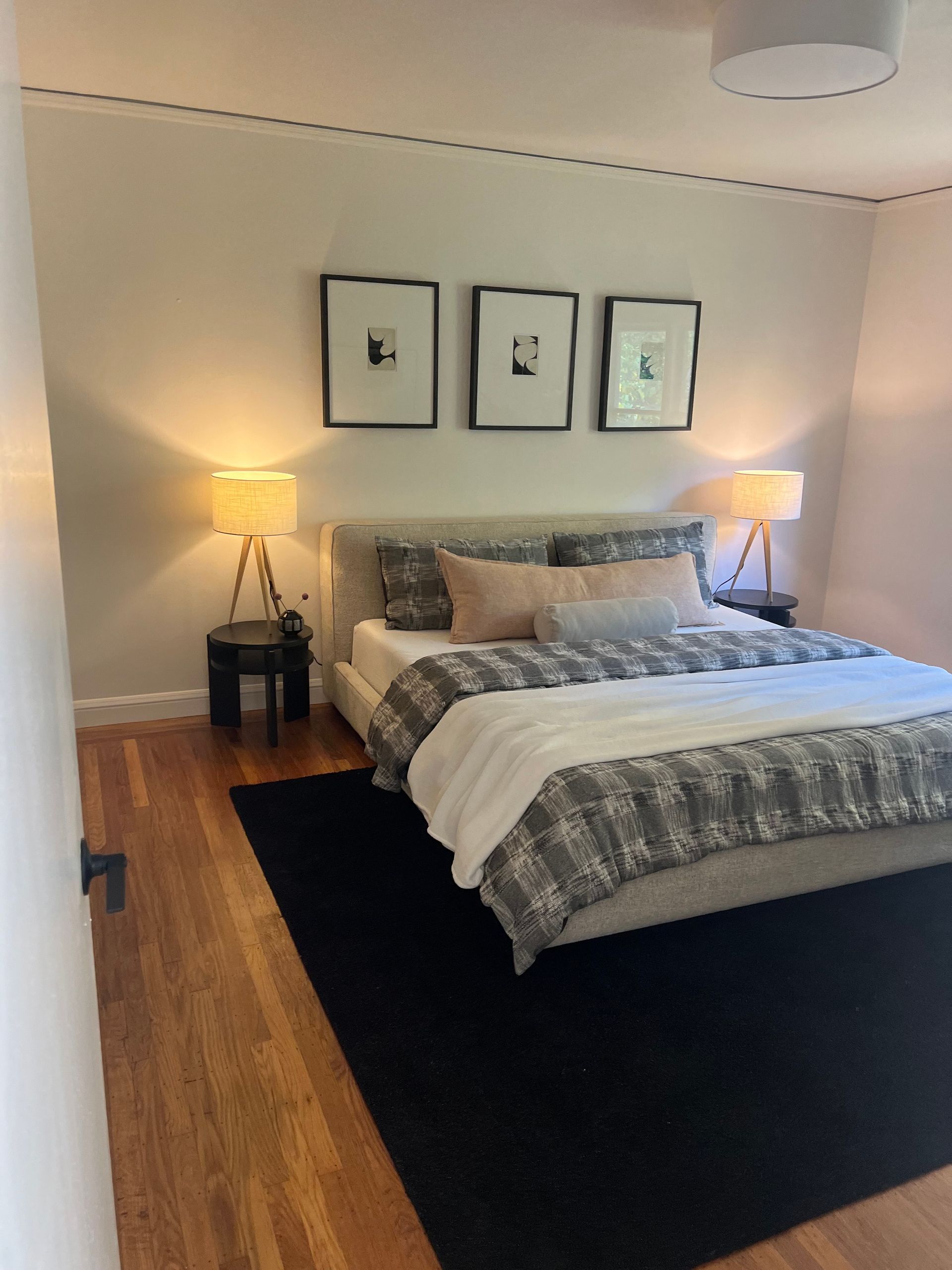 A bedroom with a bed and three pictures on the wall