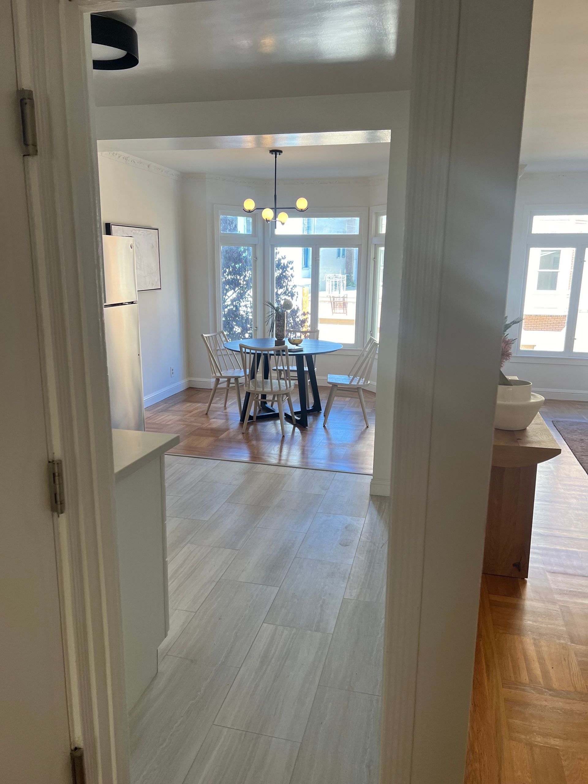 A hallway leading to a dining room with a table and chairs.