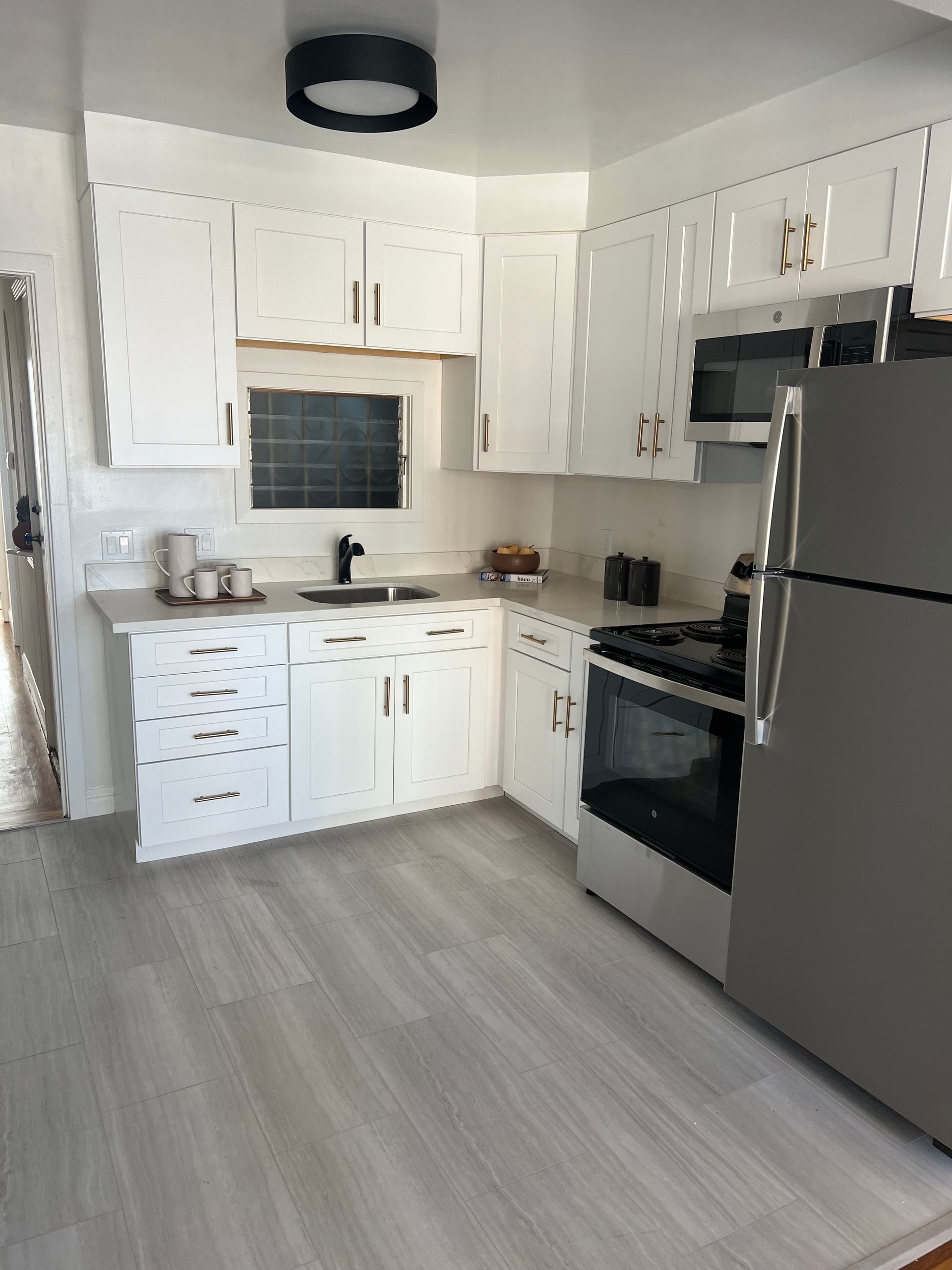 A kitchen with white cabinets and stainless steel appliances