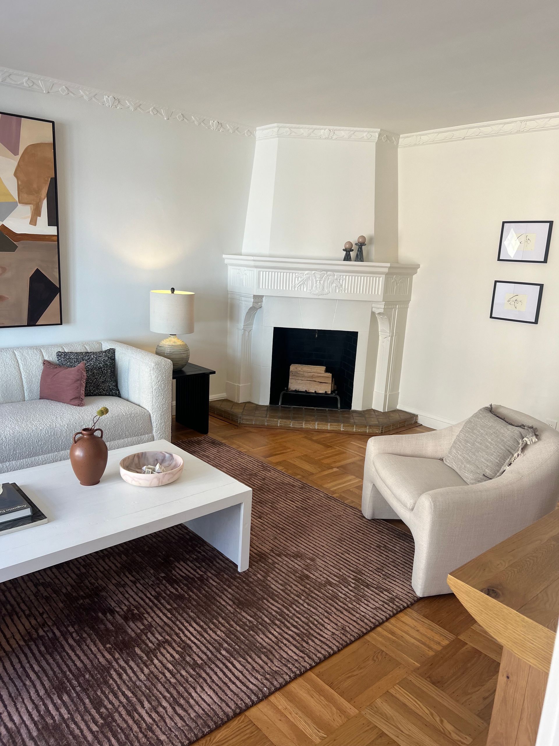 A living room with a couch , chair , coffee table and fireplace.