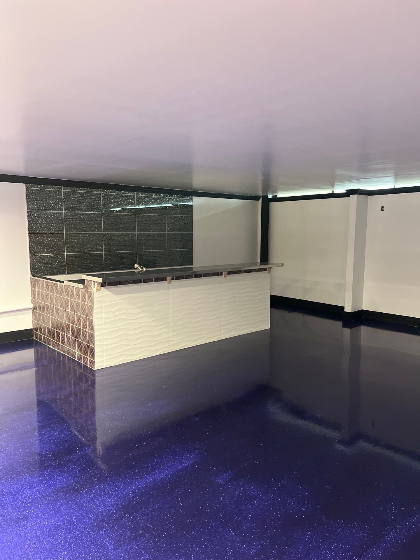 A room with a purple floor and a white counter top.