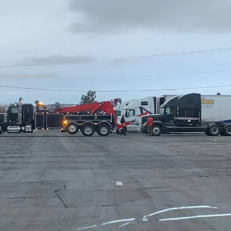 A tow truck is towing a semi truck in a parking lot — Evanston, WY — Robertson Transportation Inc. Towing and Recovery