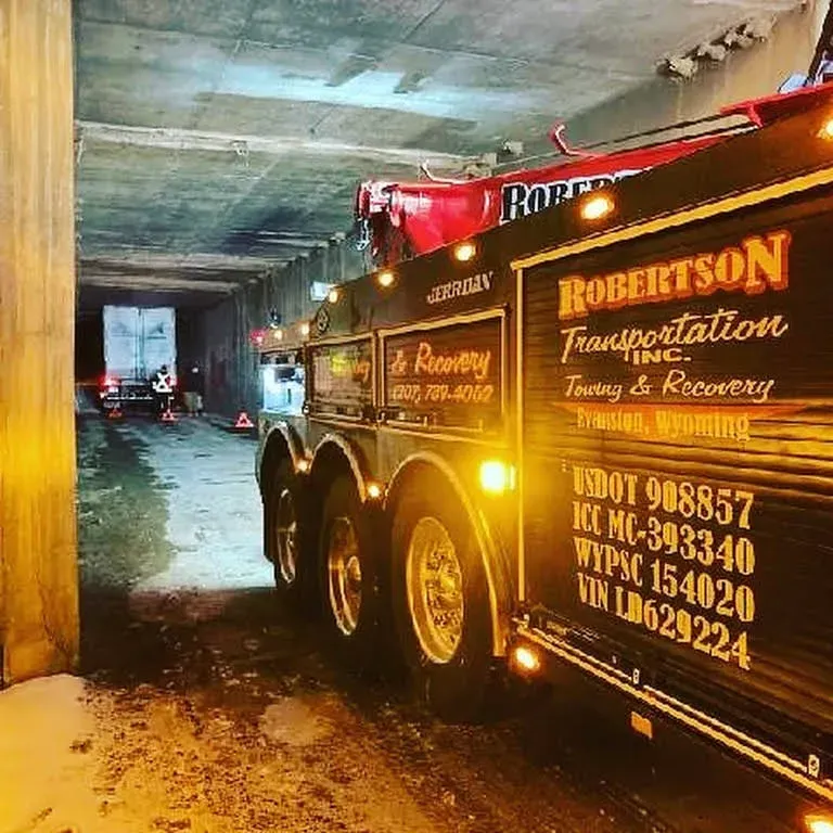 A robertson transportation truck is towing a truck in a tunnel — Evanston, WY — Robertson Transportation Inc. Towing and Recovery
