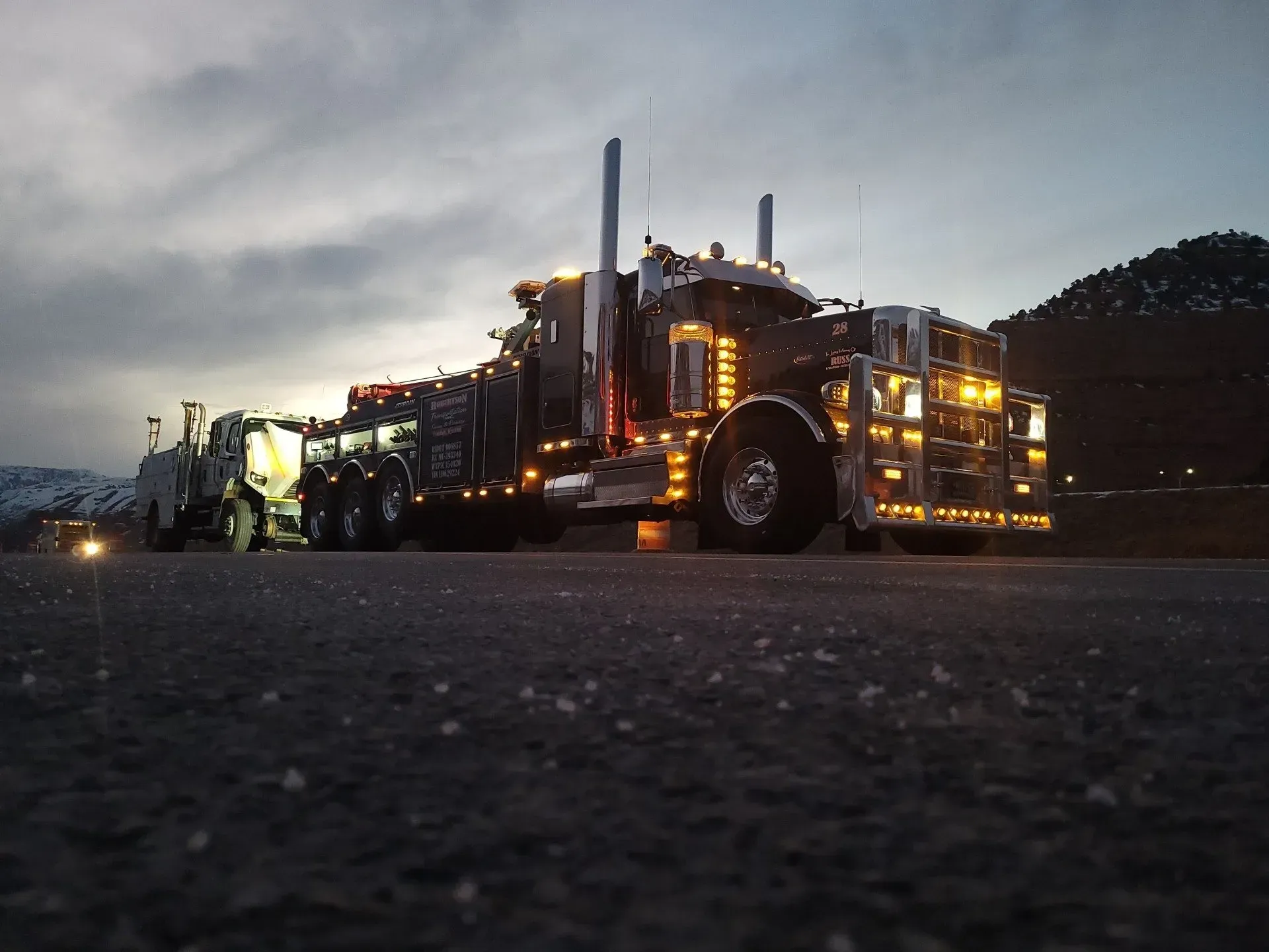 A large semi truck is parked on the side of the road at night — Evanston, WY — Robertson Transportation Inc. Towing and Recovery