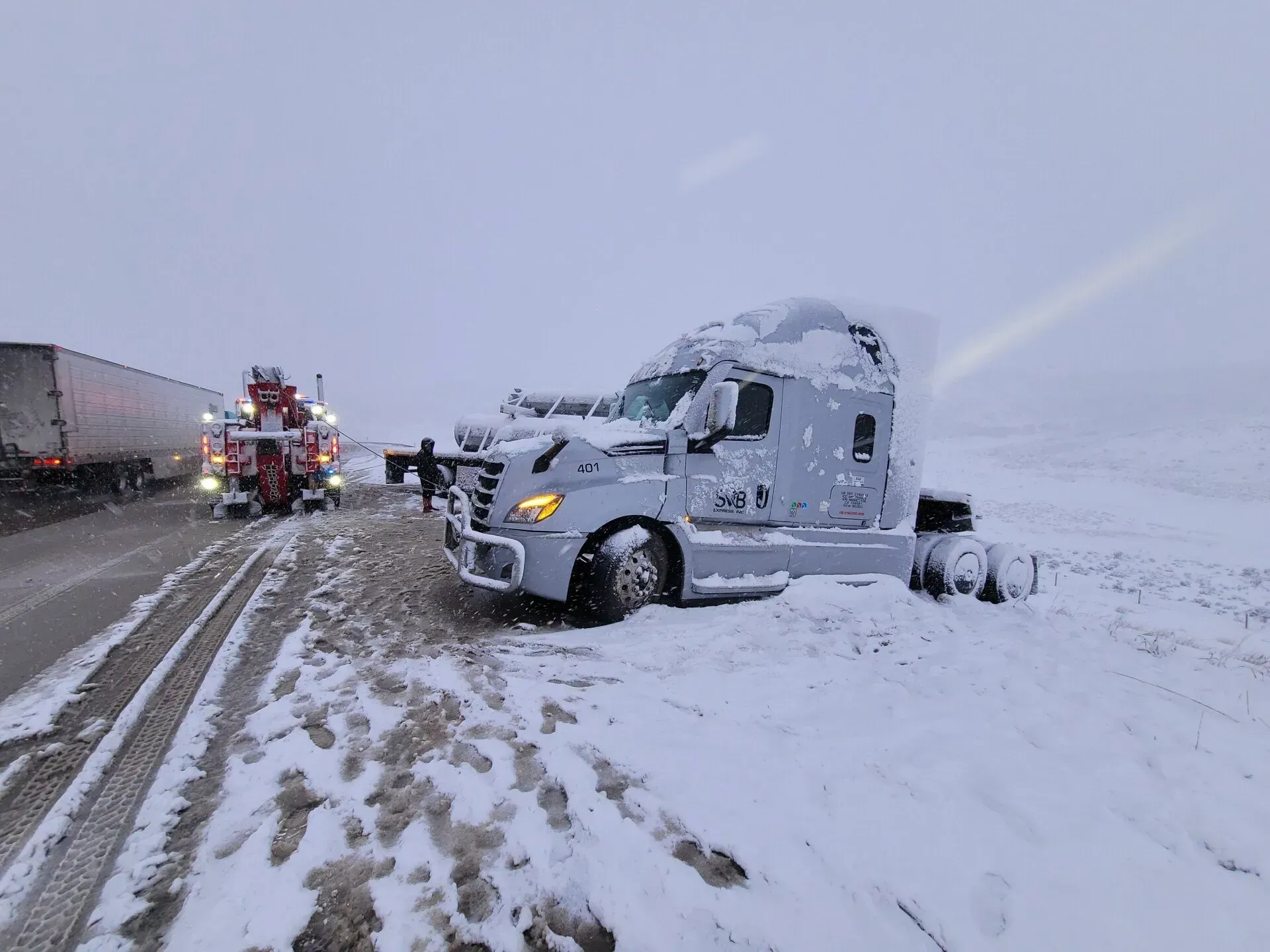 A semi truck is stuck in the snow on the side of the road — Evanston, WY — Robertson Transportation Inc. Towing and Recovery
