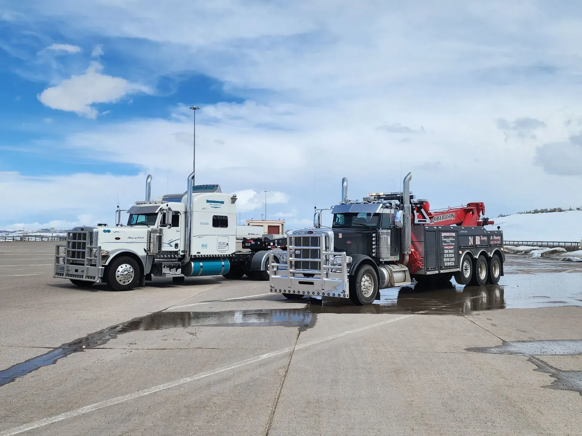 Two semi trucks are parked next to each other in a parking lot — Evanston, WY — Robertson Transportation Inc. Towing and Recovery
