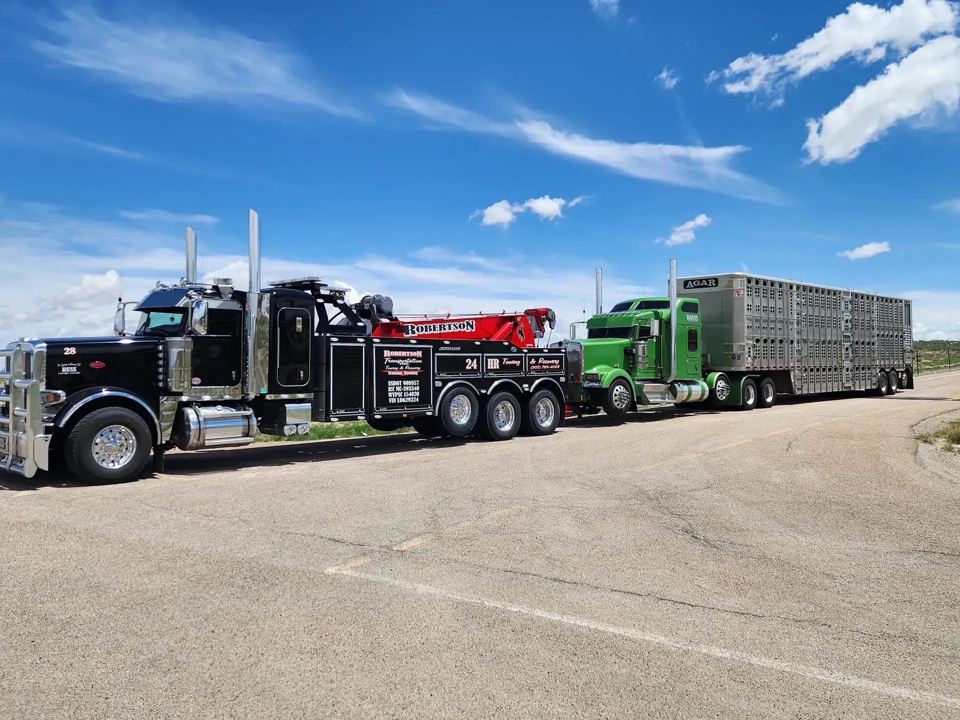 A row of tow trucks are parked on the side of the road — Evanston, WY — Robertson Transportation Inc. Towing and Recovery