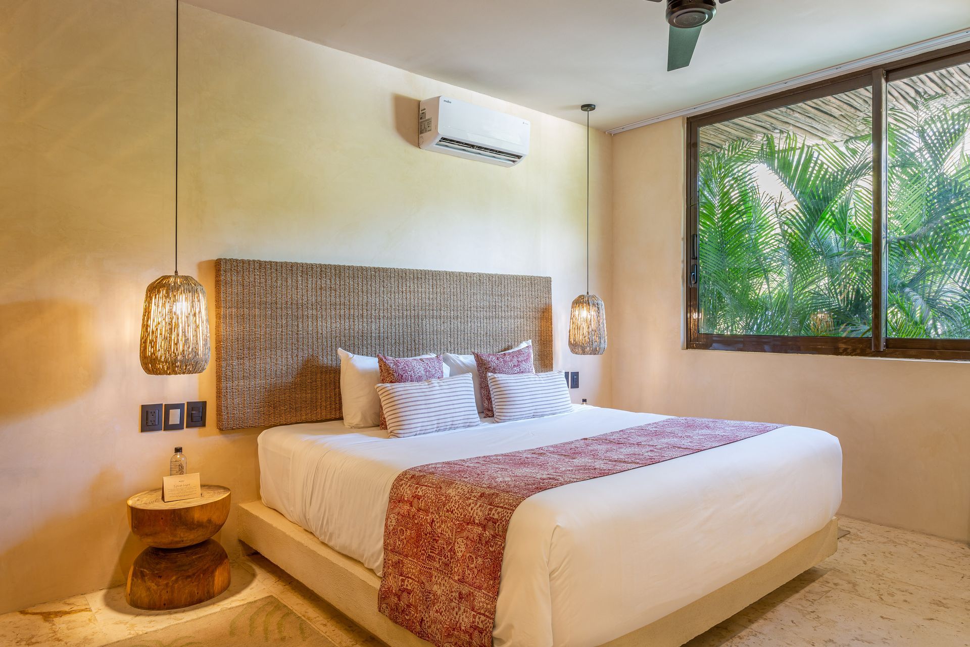 A hotel room with a large bed and a ceiling fan.
