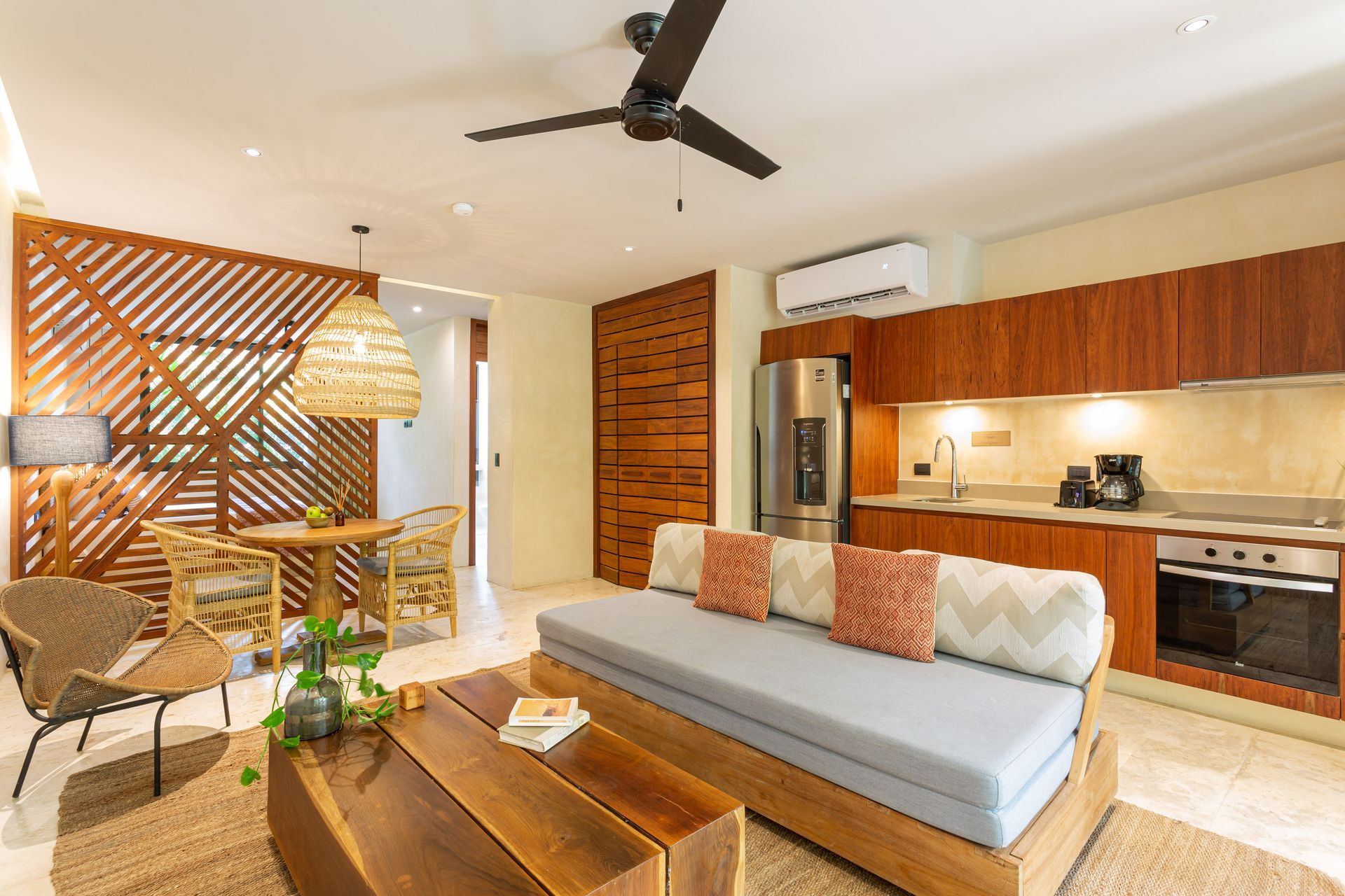 A living room with a couch , table , chairs and a ceiling fan.