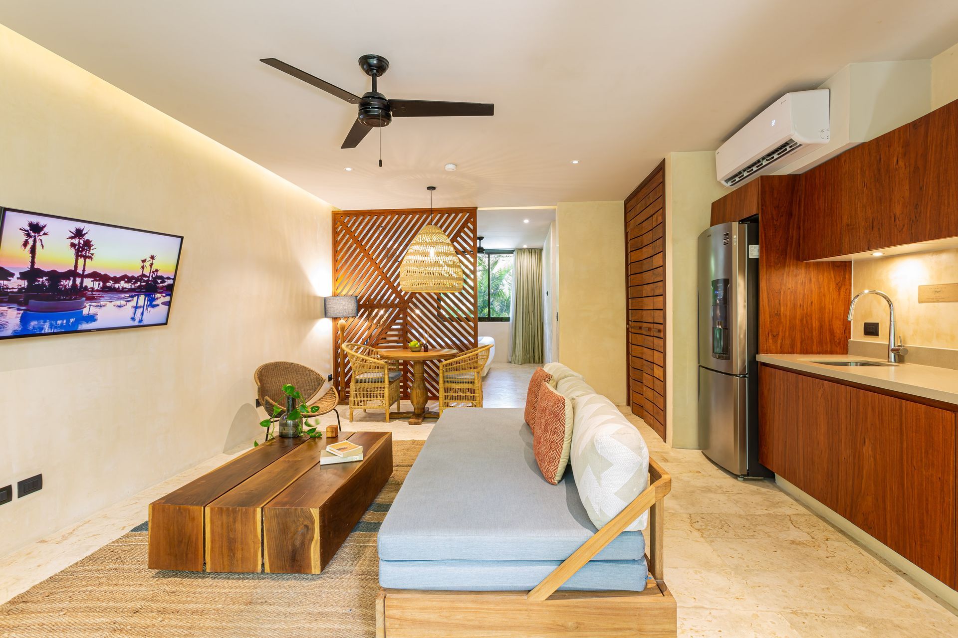 A living room with a couch , coffee table , television and ceiling fan.