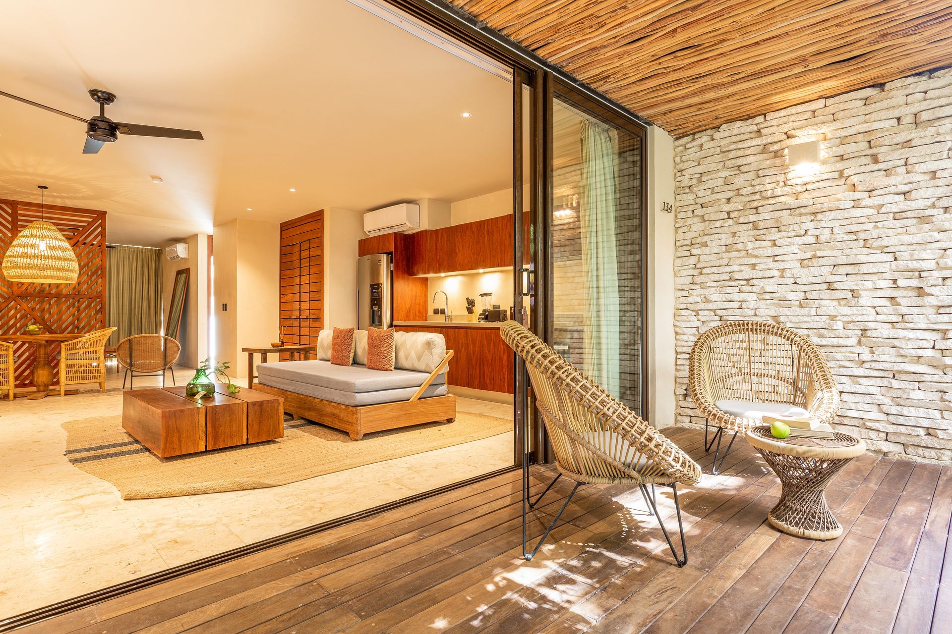 A living room with a couch , chairs , a table and a ceiling fan.