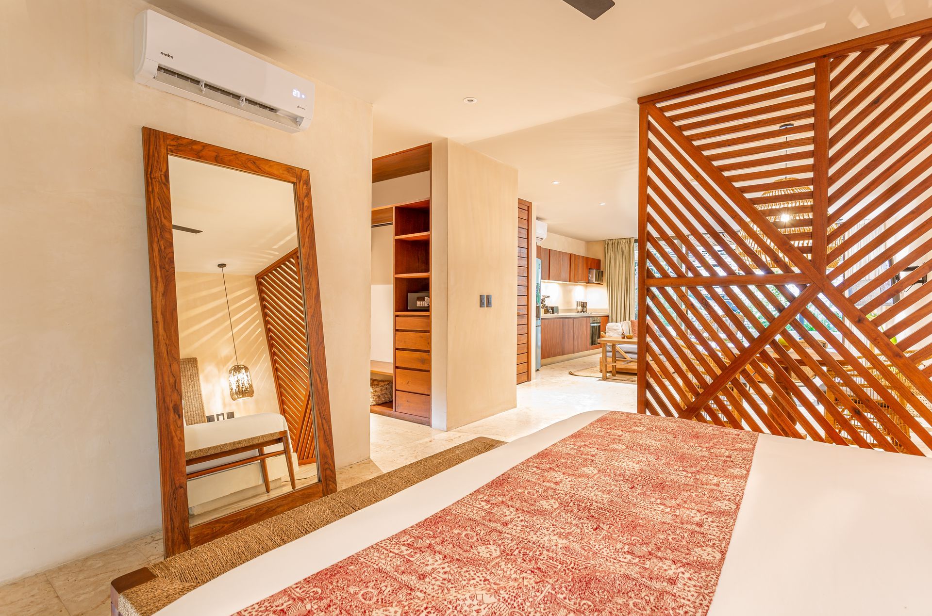 A bedroom with a large bed , a mirror , and a wooden divider.