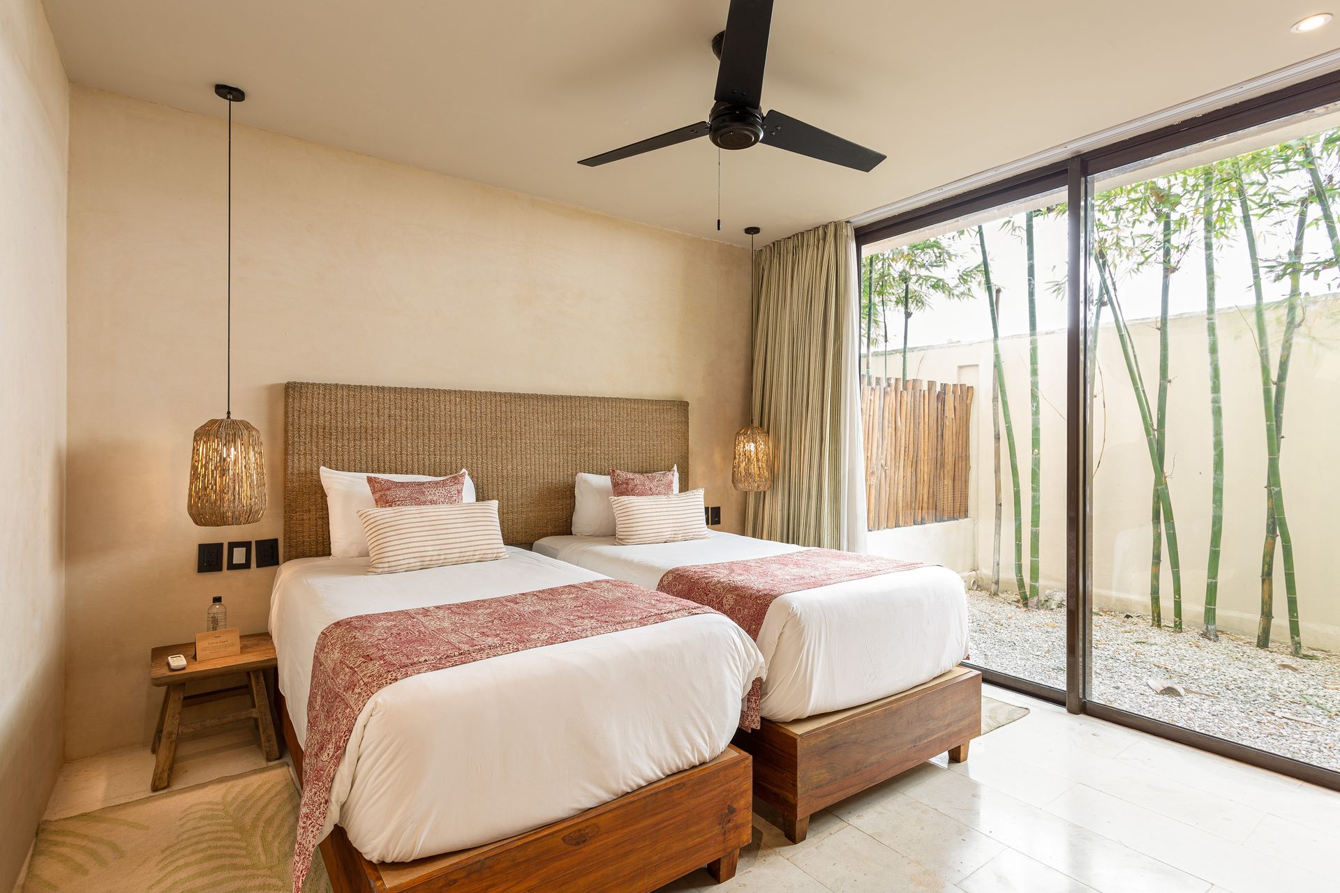 A bedroom with two beds and a ceiling fan.