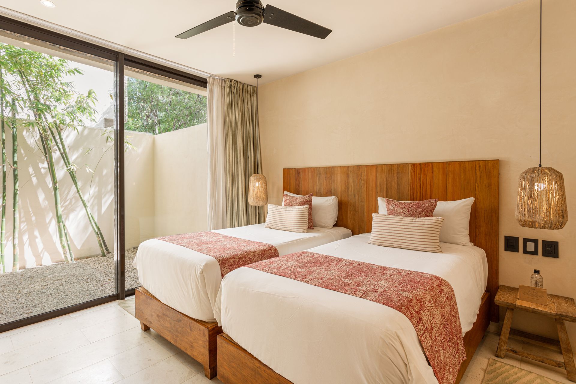 A hotel room with two beds and a ceiling fan.