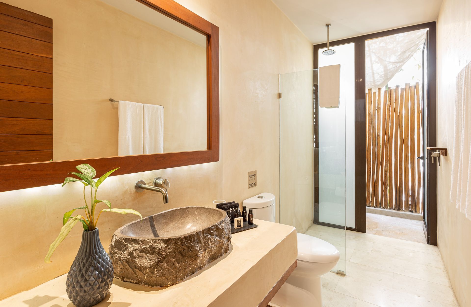 A bathroom with a sink , toilet and mirror.