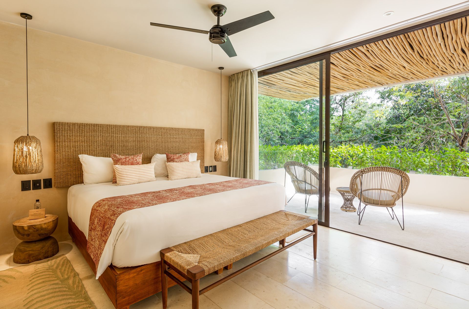 A bedroom with a large bed and a ceiling fan.