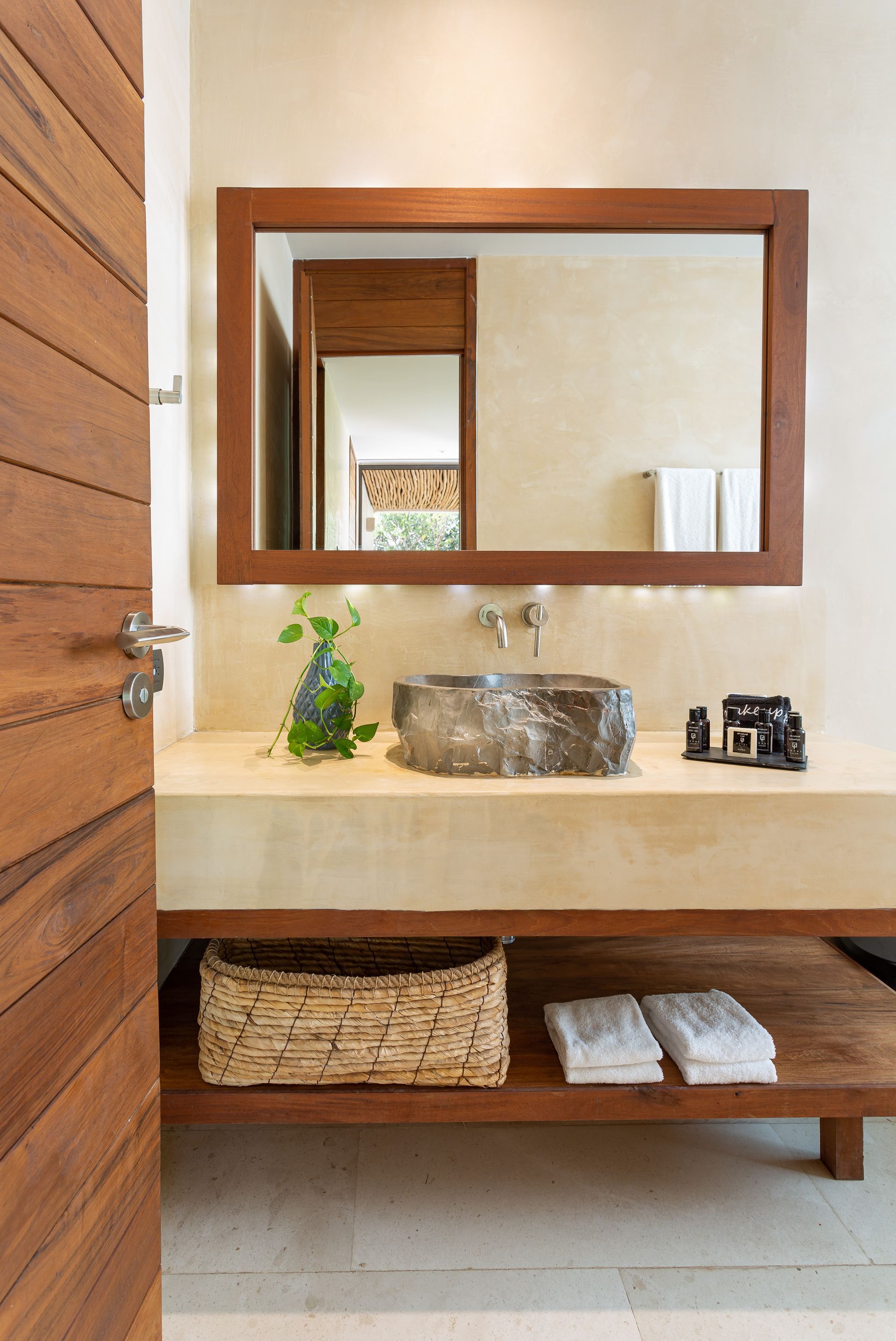 A bathroom with a sink , mirror and towels.