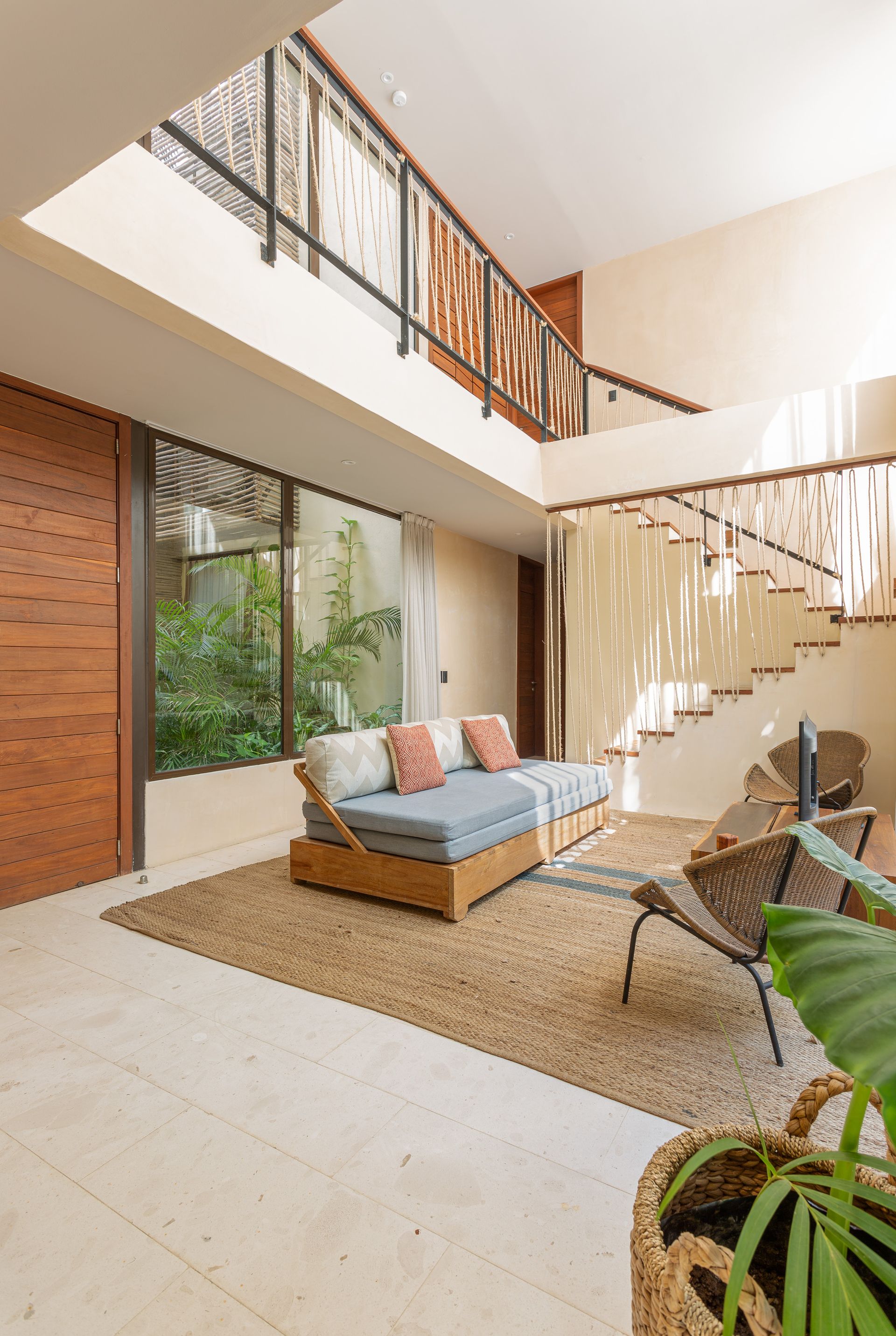 A living room with a couch , chairs , and stairs.