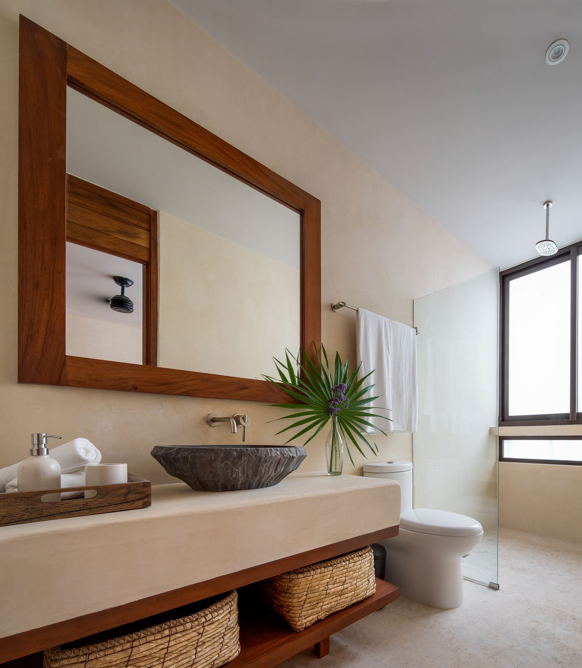 A bathroom with a sink a toilet and a large mirror