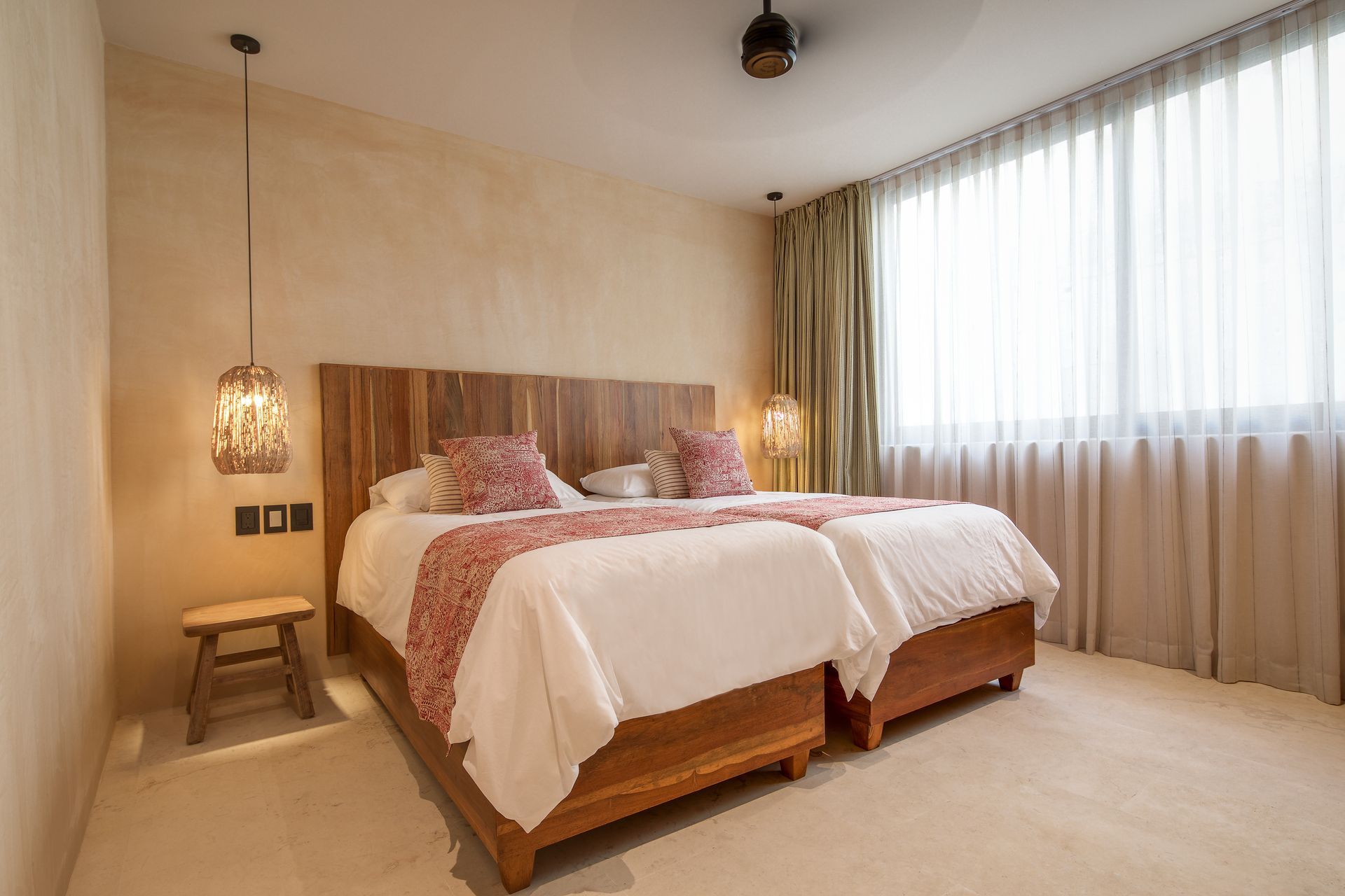 A hotel room with two beds and a window.
