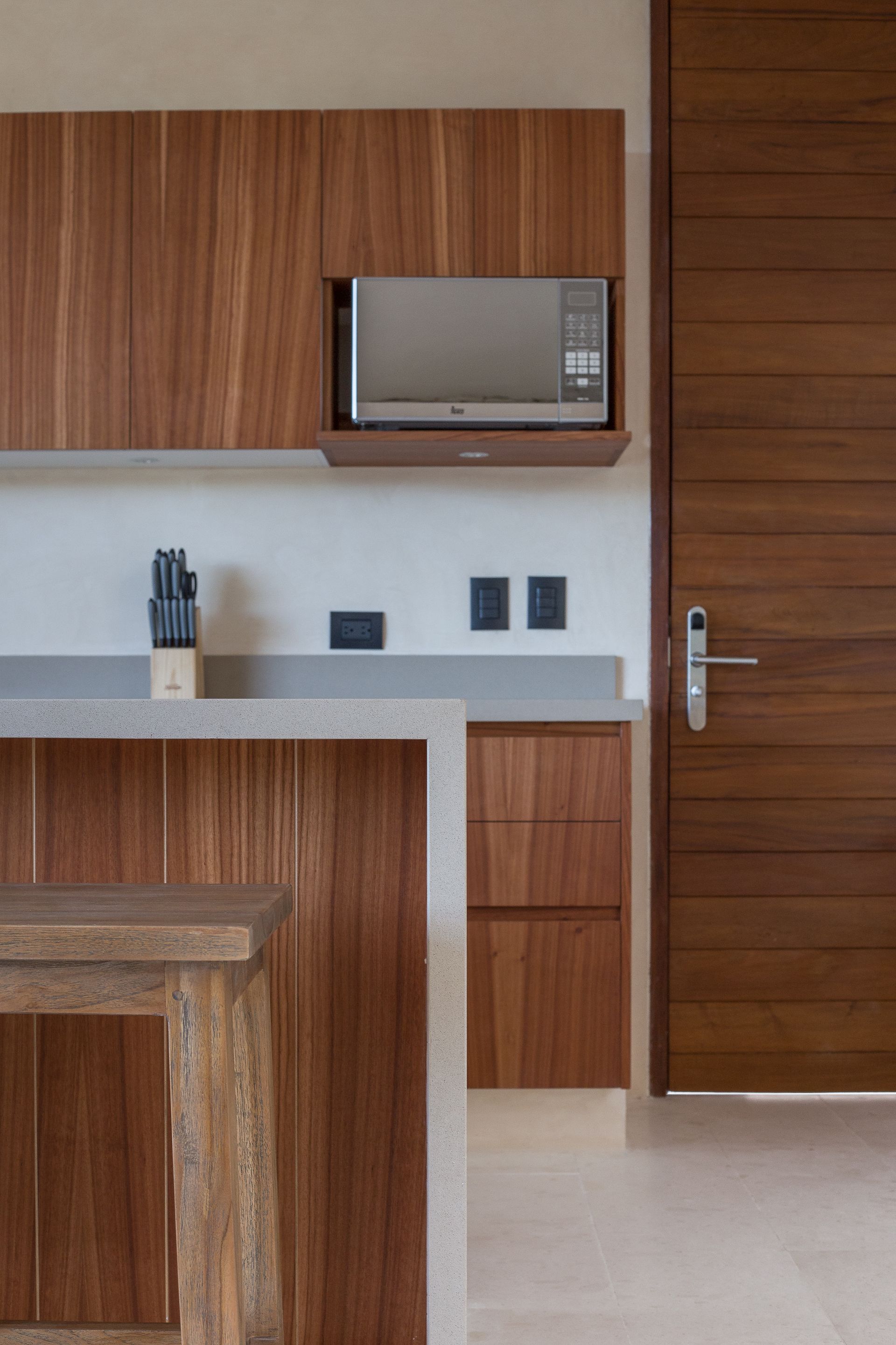 A kitchen with wooden cabinets and a microwave above the counter